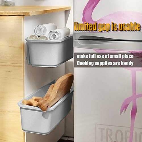 Kitchen storage bins on side of fridge with cooking supplies.